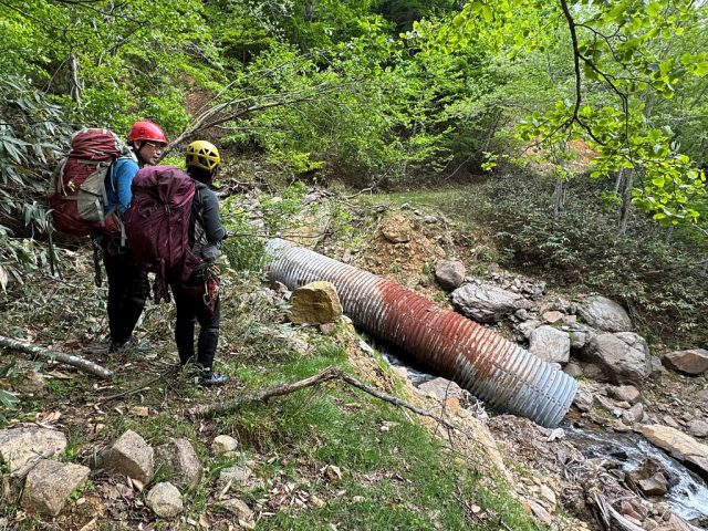 橋が流失しむき出しになったコルゲートパイプ